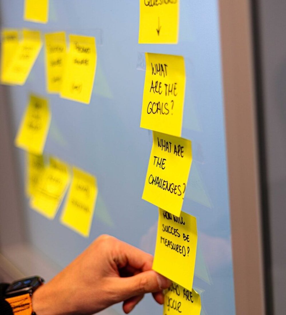 a hand holding a yellow sticky note