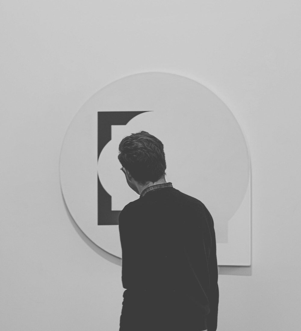 a man standing in front of a white wall